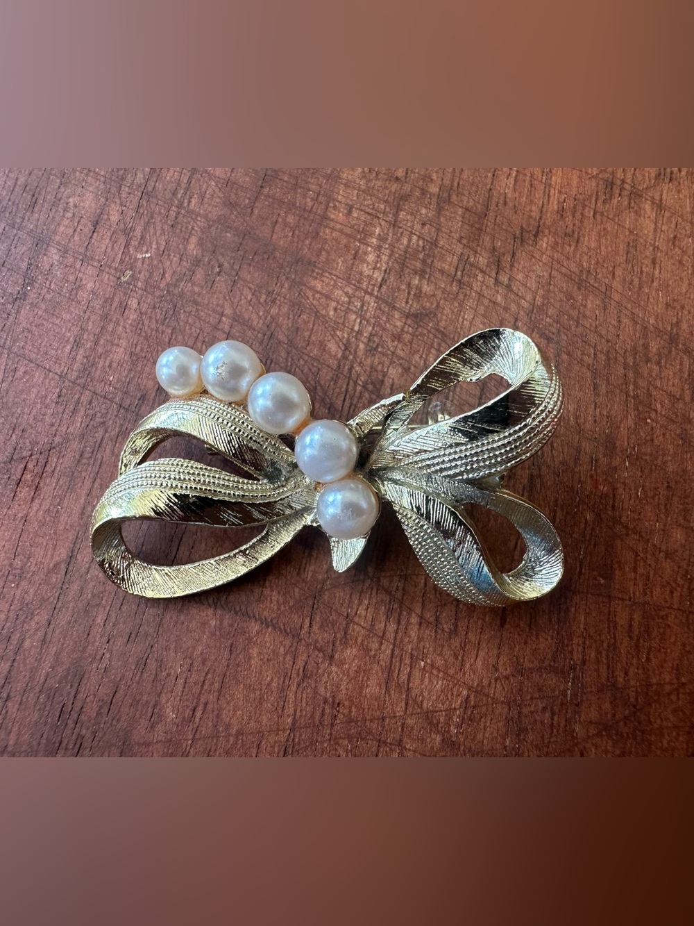 Estate vintage mid-century gold-tone ribbon bow brooch featuring faux pearls.